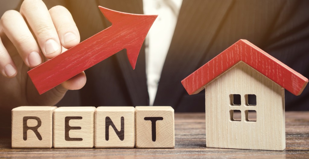 Wooden Blocks With The Word Rent, House And Up Arrow. The Concept Of The High Cost Of Rent For An Apartment Or Home. Interest Rates Are Rising. Real Estate Market. Increased Demand For Rental Property