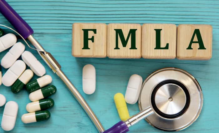 Fmla Acronym On Wooden Cubes On A Blue Background With A Stethoscope And Tablets