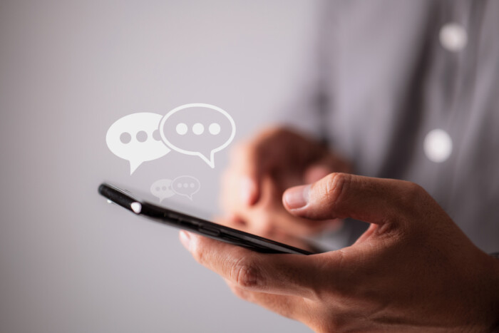 Men Hands Are Typing On Their Smartphones, And Chat Box Symbols Appear. Concept Of Social Media Marketing Technology.