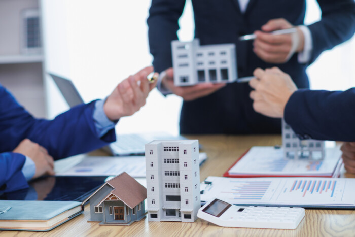 Group Of Businessmen And Investors Discuss Investing In Real Estate And Jointly Plan Investments In Construction Projects Of Condominiums And Apartments For Sale And Rent. Investment Advisory Concept