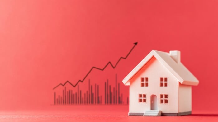 Small Model House On Red Background With Ascending Graph Representing Real Estate Market Growth And Investment Trends For Financial Prosperity