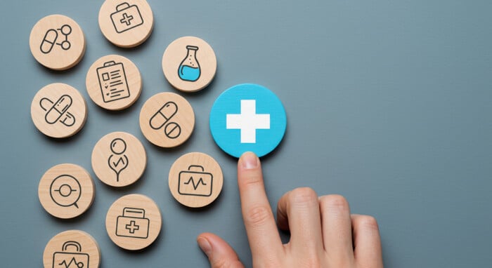 Medical Icons And A Hand Highlighting The Plus Sign, Symbolizing