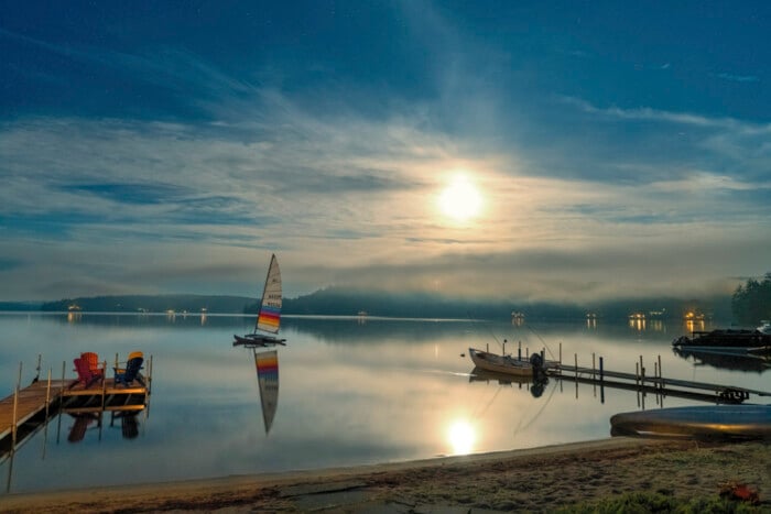 Nighttime Photograph Of Squam Lake Showing A Dock, Sailboat And
