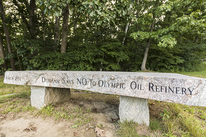 een bankje bij Wagon Hill Farm ter herdenking van de succesvolle strijd om de installatie van een olieraffinaderij te Durham Point In Durham, New Hampshire.er is weinig bewijs over van de strijd tussen de bewoners van Durham en de oliemagnaat Aristoteles Onassis, maar deze granieten bank is een duurzame getuige van de overwinning van lokale activisten. Foto door Jerry Monkman