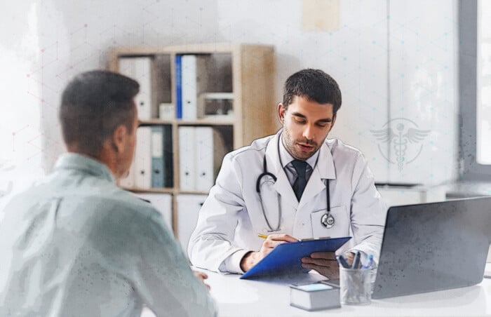 Doctor With Clipboard And Male Patient At Hospital