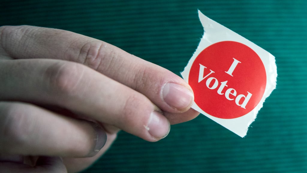 voter-holding-an-i-voted-sticker-at-election-voting-jpg-jpg_13245607_ver1-0.jpg