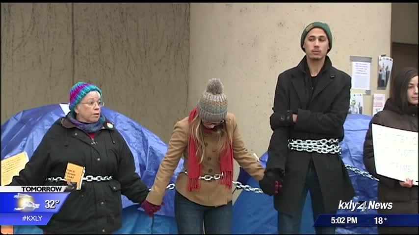 Protesters chain themselves together, continue protest over lack of warm shelters