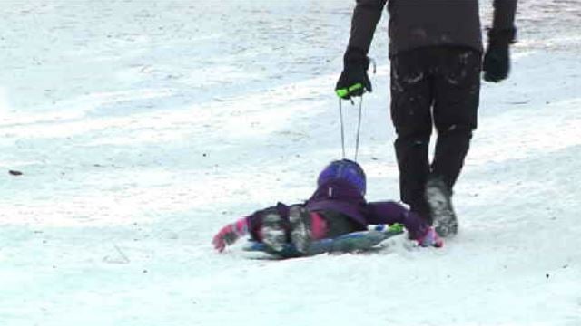 Dozens of families brave bad roads, gusty winds for sledding