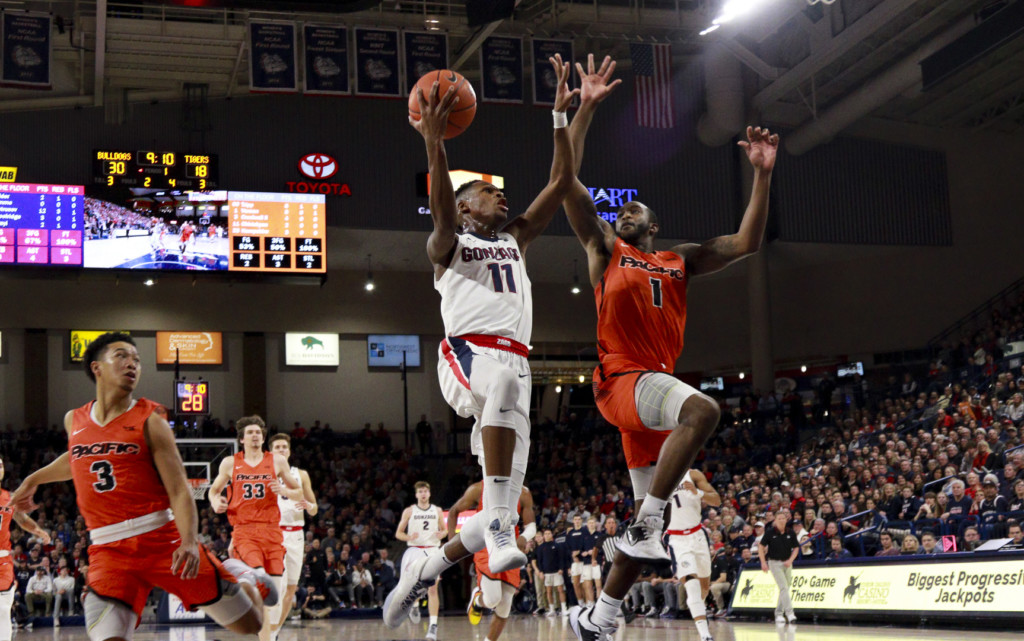 Gonzaga's Joel Ayayi gives Pacific's Austin Vereen a high-five while driving to the hoop.