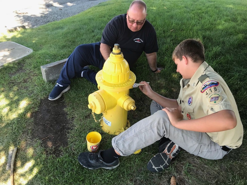 Mitchell Burch paints fire hydrants in Spokane Valley