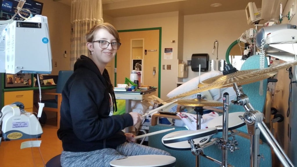 Lucy Riggs plays the drum while going through cancer treatment.