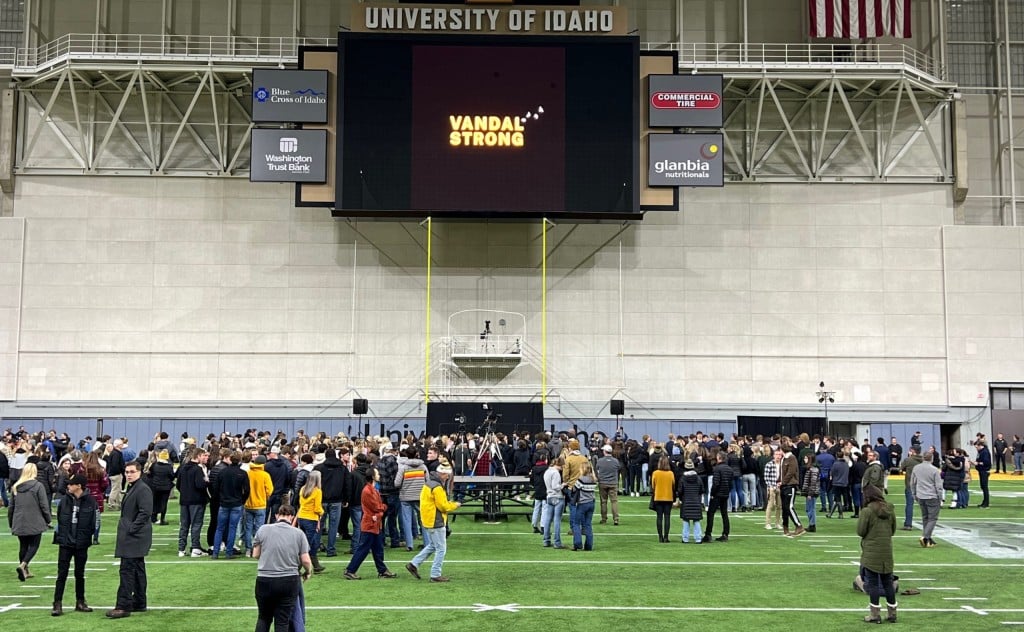 People gathering inside the Kibbie Dome in Moscow, Idaho for a candlelight vigil. Big screen monitor reads "Vandal Strong"