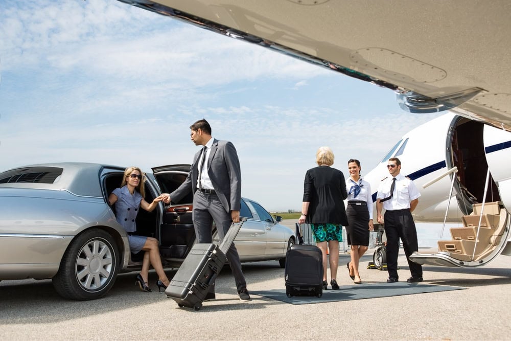 Business,partners,about,to,board,private,jet,while,airhostess,and