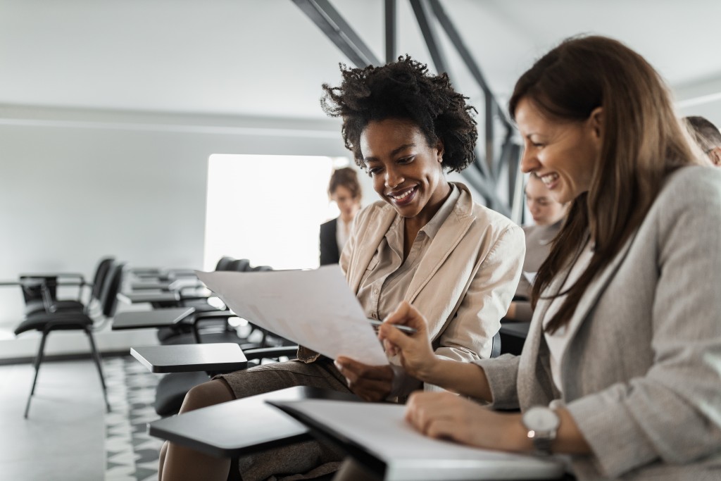 Two,females,in,a,suits,,doing,paper,work.