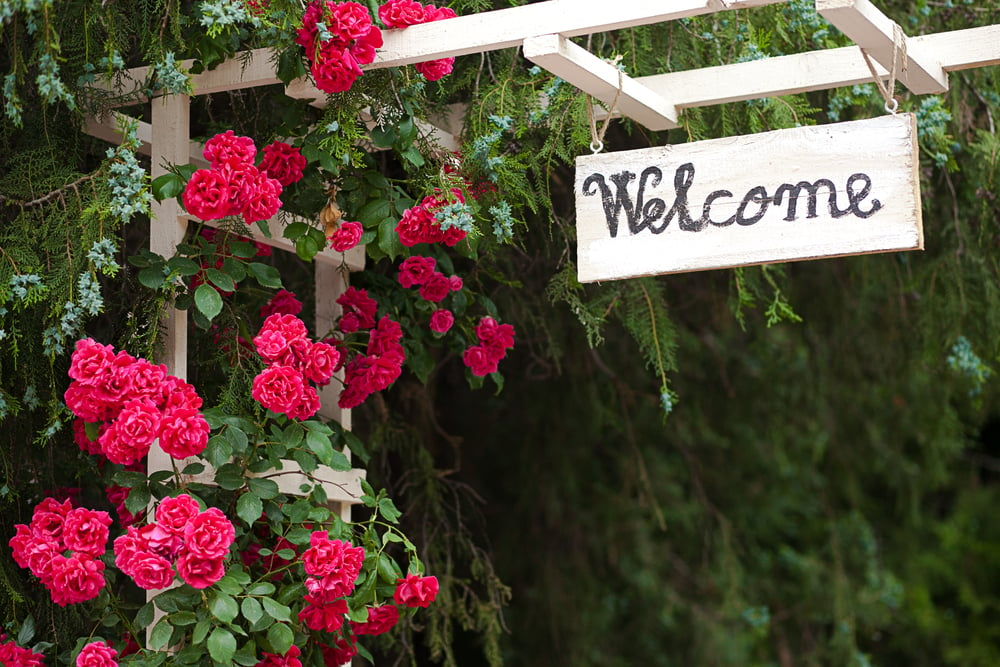 Red,flowers,and,welcome,wood,panel,at,hotel,entrance