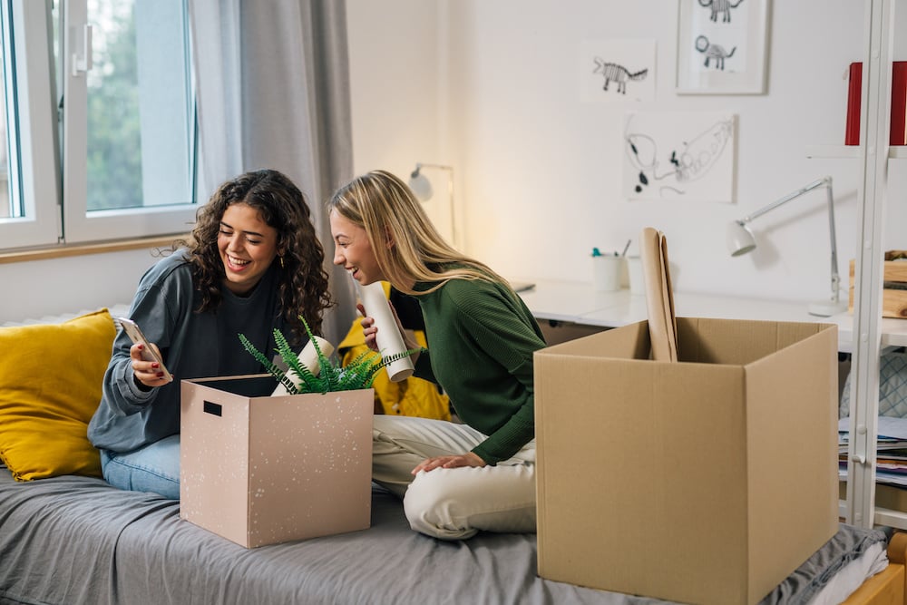 College Female Teenagers Sits On Bed And Using Mobile Phone Dormitory
