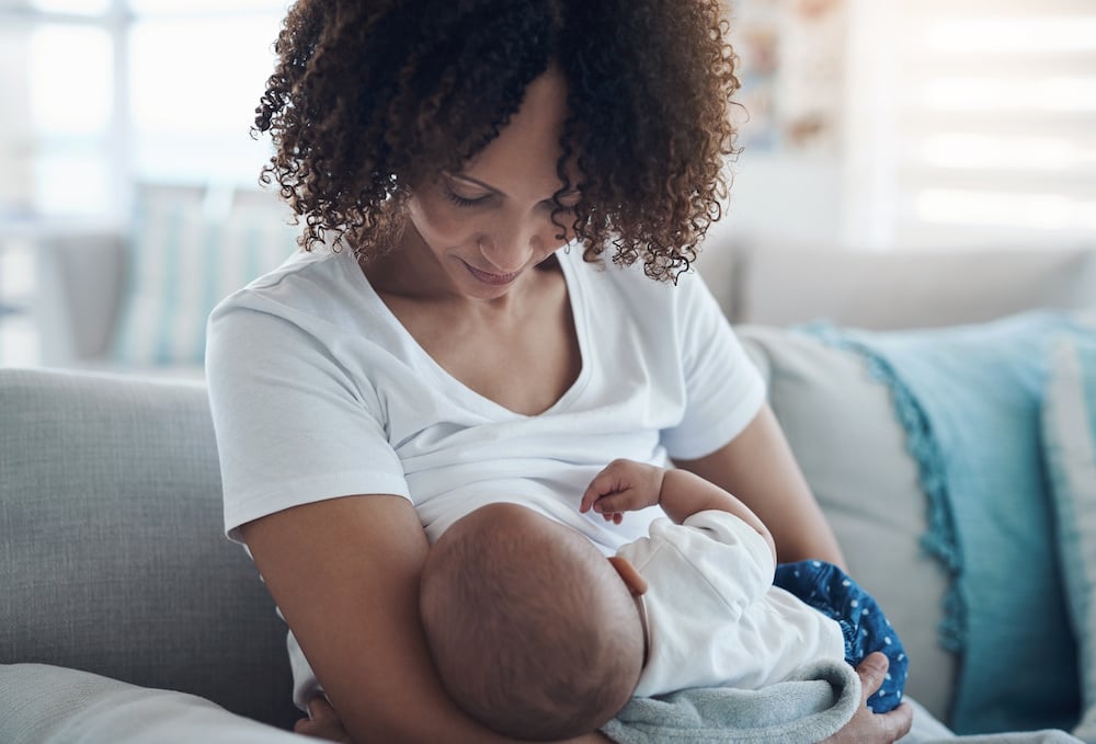 Love, Living Room And Mother Breastfeeding Her Baby For Health, Nutrition And Wellness At Home. Bonding, Care And Young Woman Nursing Or Feeding Her Newborn Child Milk On The Sofa In The Family House