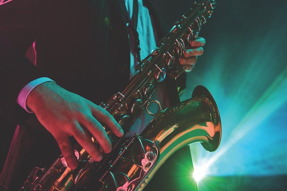 Jazz Musician Performing With Saxophone Under Vibrant Stage Lights