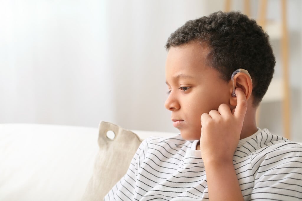 Little African American Boy With Hearing Aid At Home
