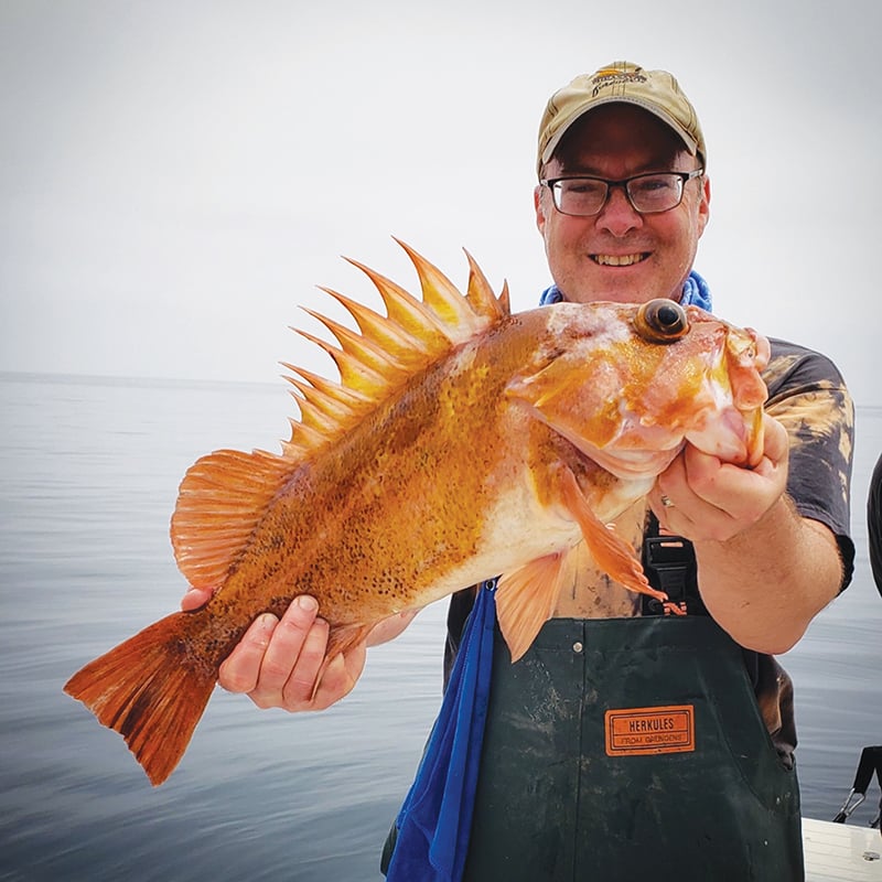 Hank Shaw holding out a large orange fish