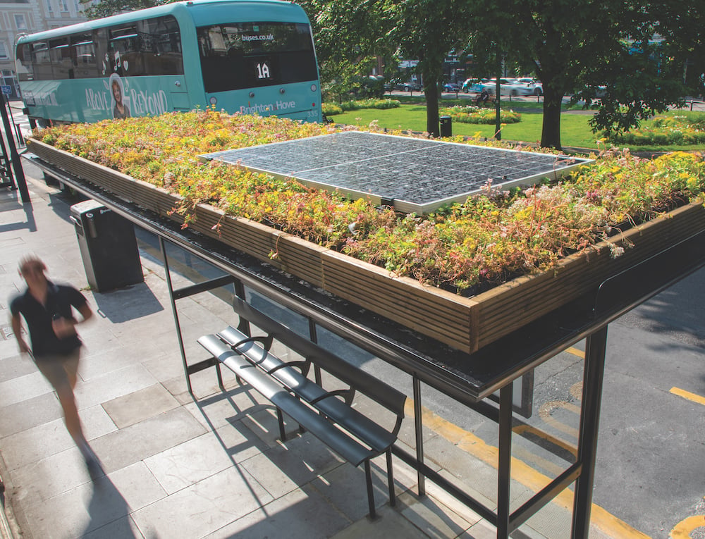 A bus stop with a small garden and a solar panel on top