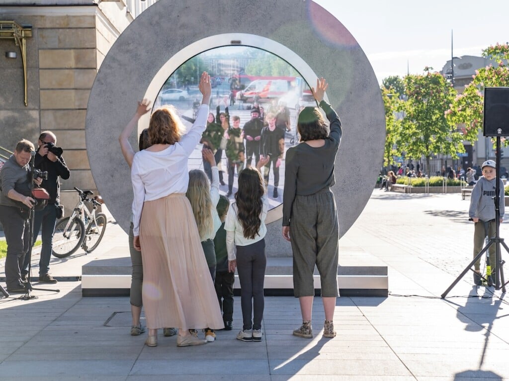 People standing in front of a Portal, waving