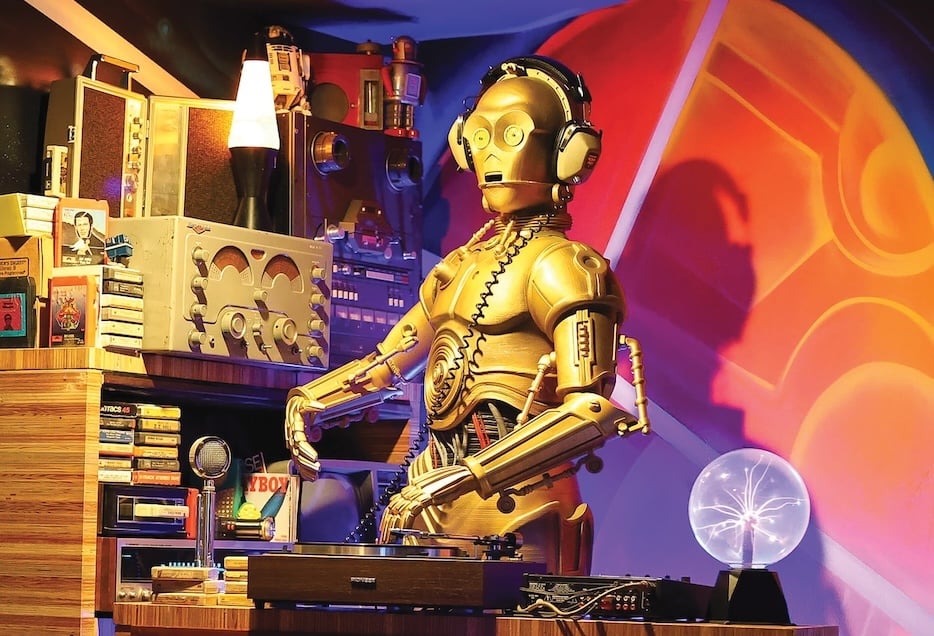 A C-3PO statue set up behind a turntable.