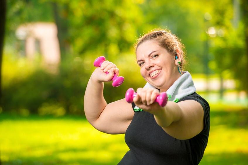 Portrait Of Smiling Plus Size Woman With Dumbbells In The Park D