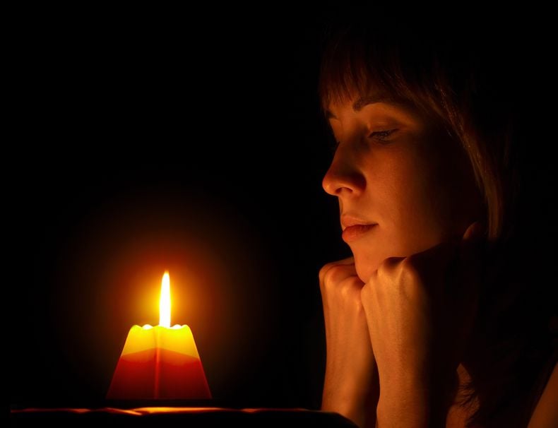 Young Woman Looking To A Candle