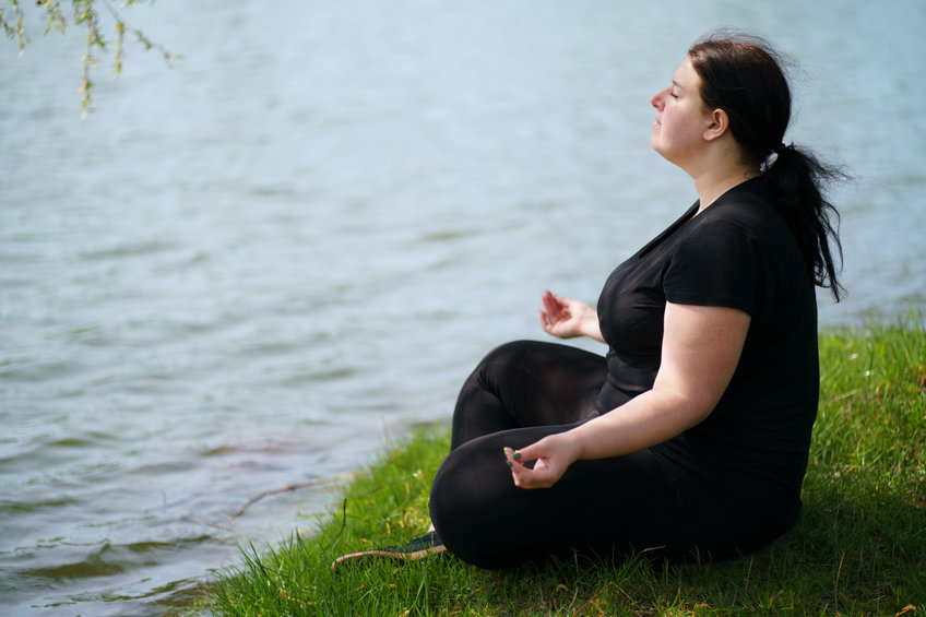 Overweight Woman Meditating Sitting Outdoors