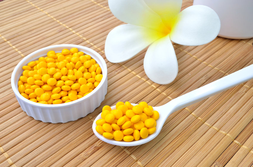 Yellow Medicine Tablet On The Spoon And White Flower