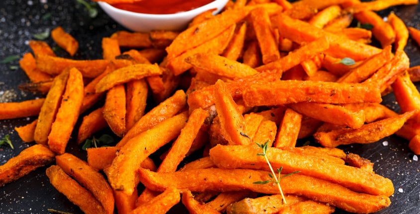 Healthy Homemade Baked Orange Sweet Potato Fries With Ketchup, Herbs, Salt And Pepper.
