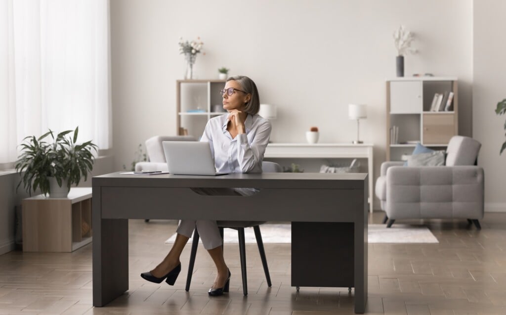 Mature Businesswoman Sit At Desk With Computer In Home Office