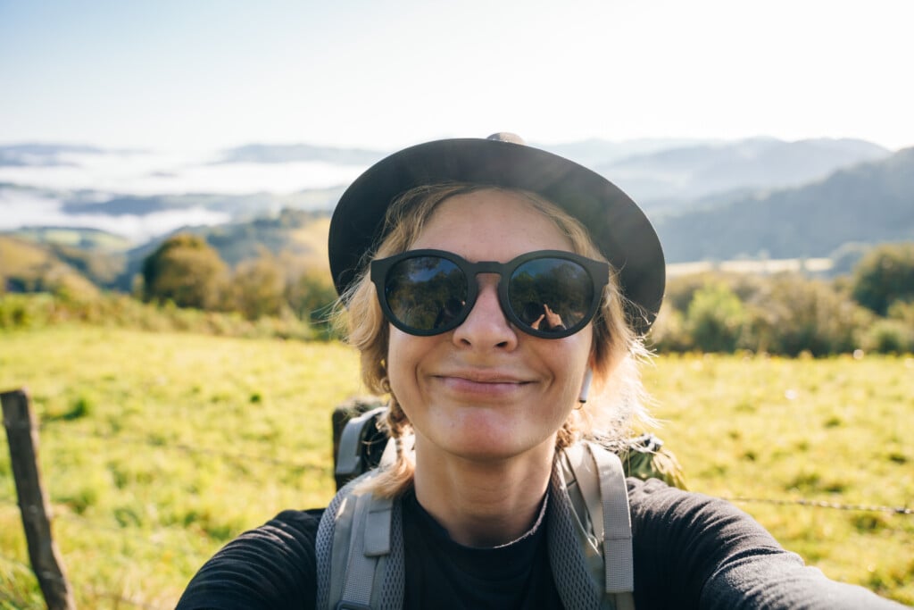 Girl Traveler Pilgrim Selfie On Camino De Santiago, To Compostela On The Pyrenees, Navarra, Spain