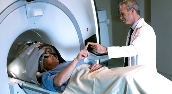 Physician Evaluates Tremor Symptoms During Insightec Ultrasound Treatment Courtesy Of Insightec Submitted 696x382