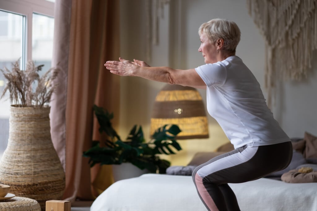 Senior Caucasian Woman Practicing Advanced Yoga Chair Pose Or Utkatasana