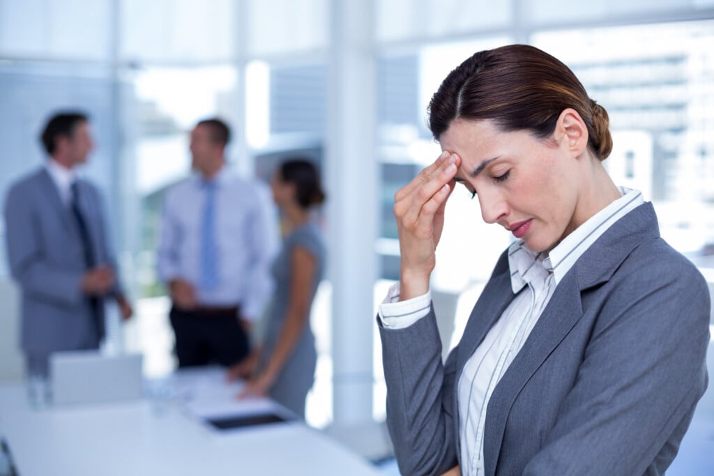Worried Businesswoman With Head In One Hand In An Office