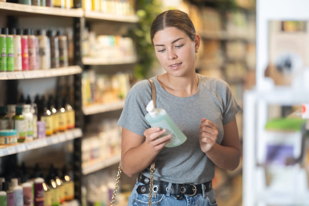 Young Woman Selecting Natural Beauty Products In Eco Store