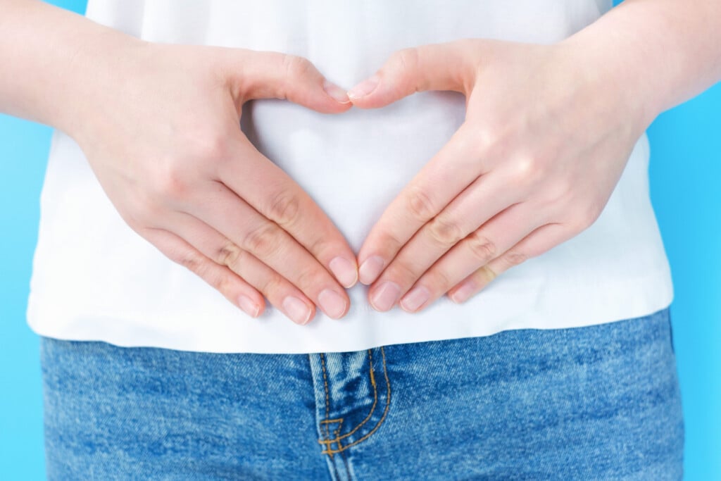 Female Hands In The Shape Of Heart On The Stomach, Concept Of Female Health.