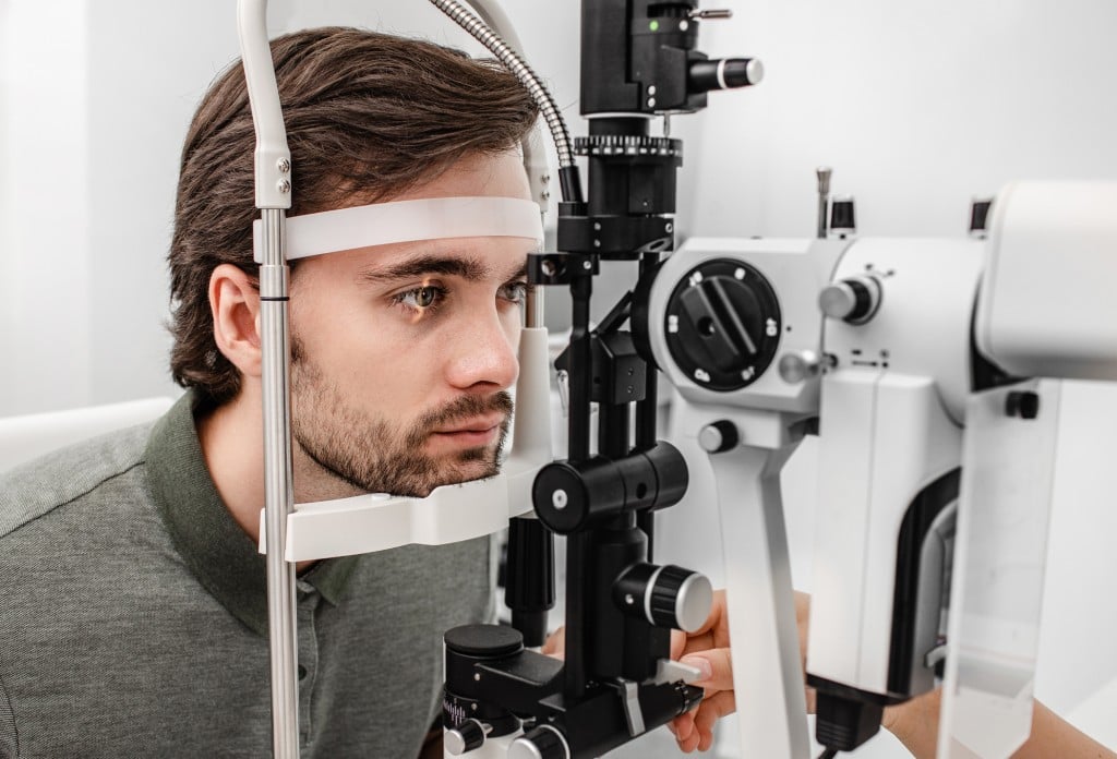 Adult Man Getting An Eye Exam At Ophthalmology Clinic. Checking Retina Of A Male Eye Close Up