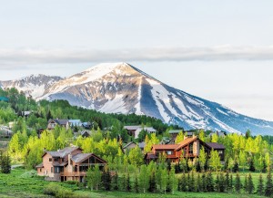 Mount Crested Butte, Colorado Village In Summer With Colorful Sunrise By Wooden Lodging Houses On Hills With Green Trees