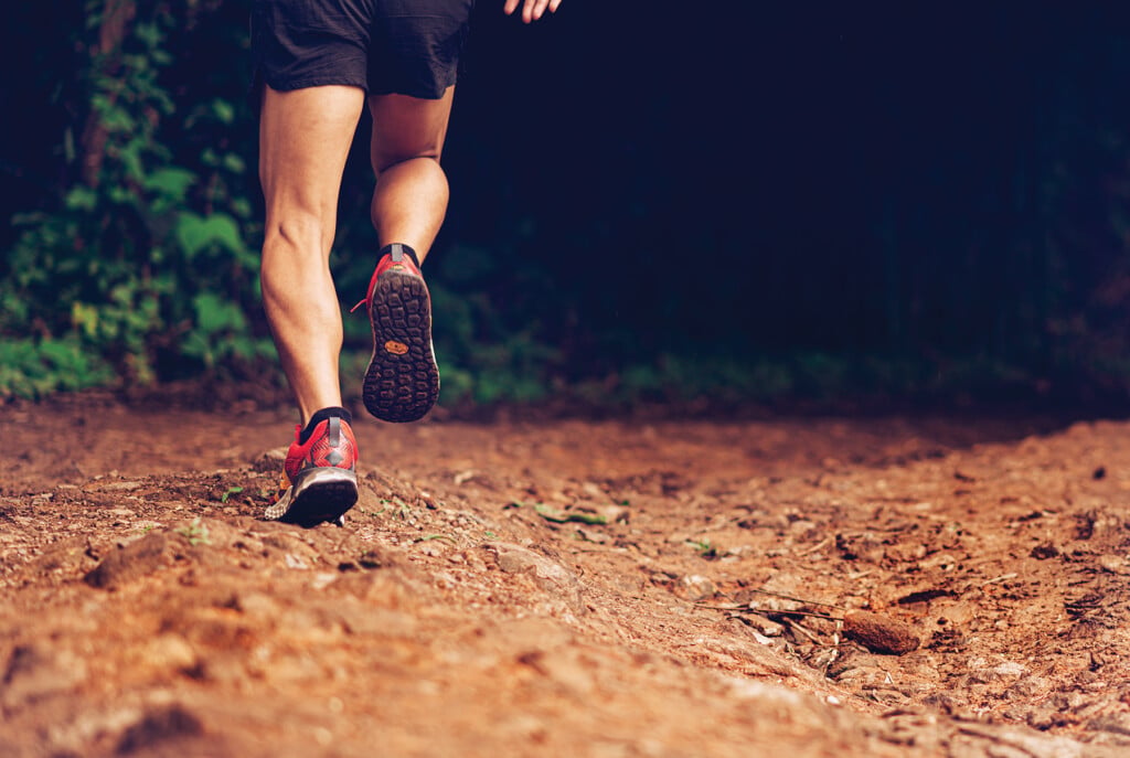 Closeup Of Man Trail Running On Rocky Terrain. Closeup Of Male F