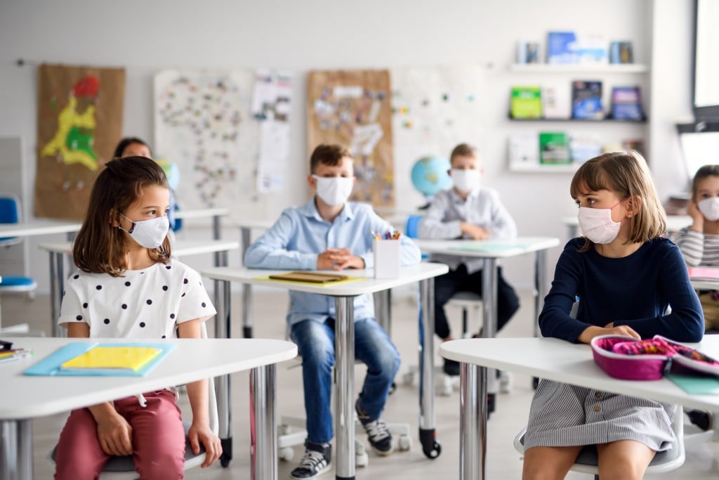 Children With Face Mask Back At School After Covid 19 Quarantine And Lockdown.