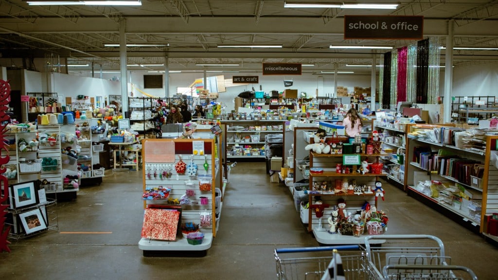 A wide angle shot of three aisles at Scraps. The aisles are lined with random mismatched goods in all different colors.