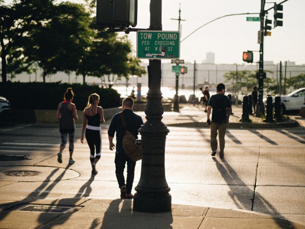 Four people jaywalk across a street