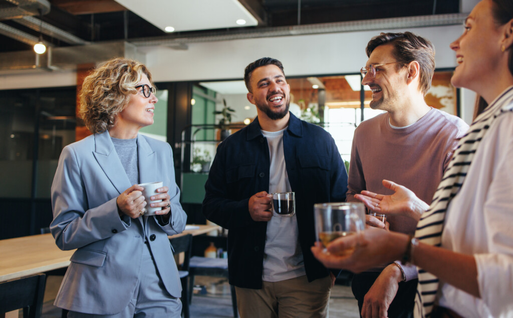group of adults standing and talking at the office