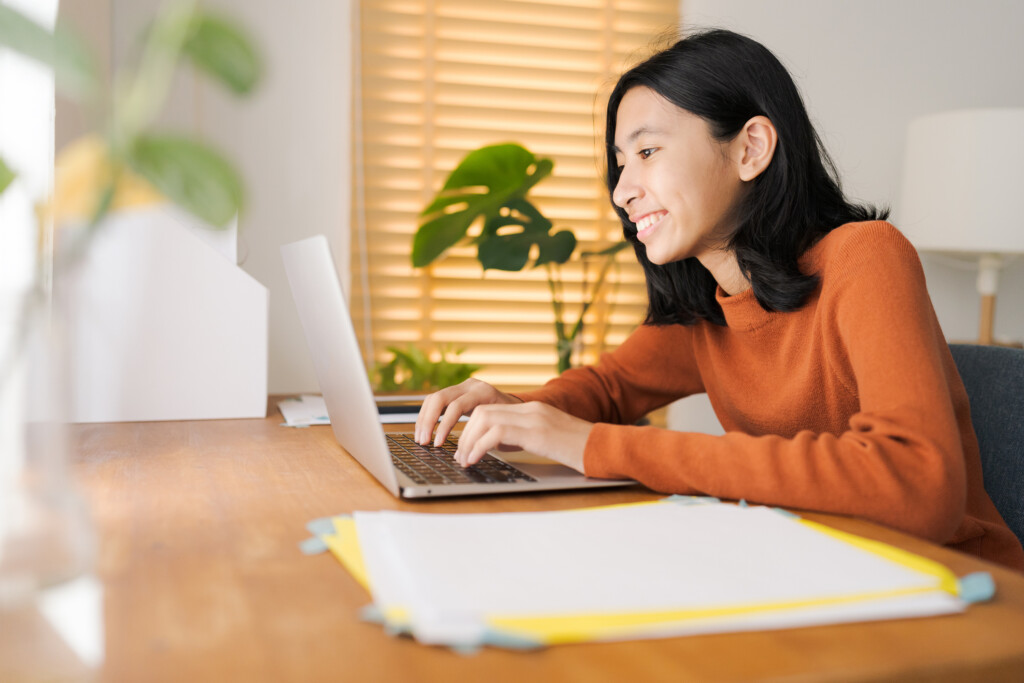 teen girl at table with laptop