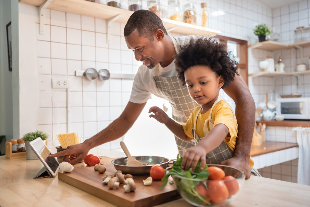 father and young boy cooking together in the kitchen