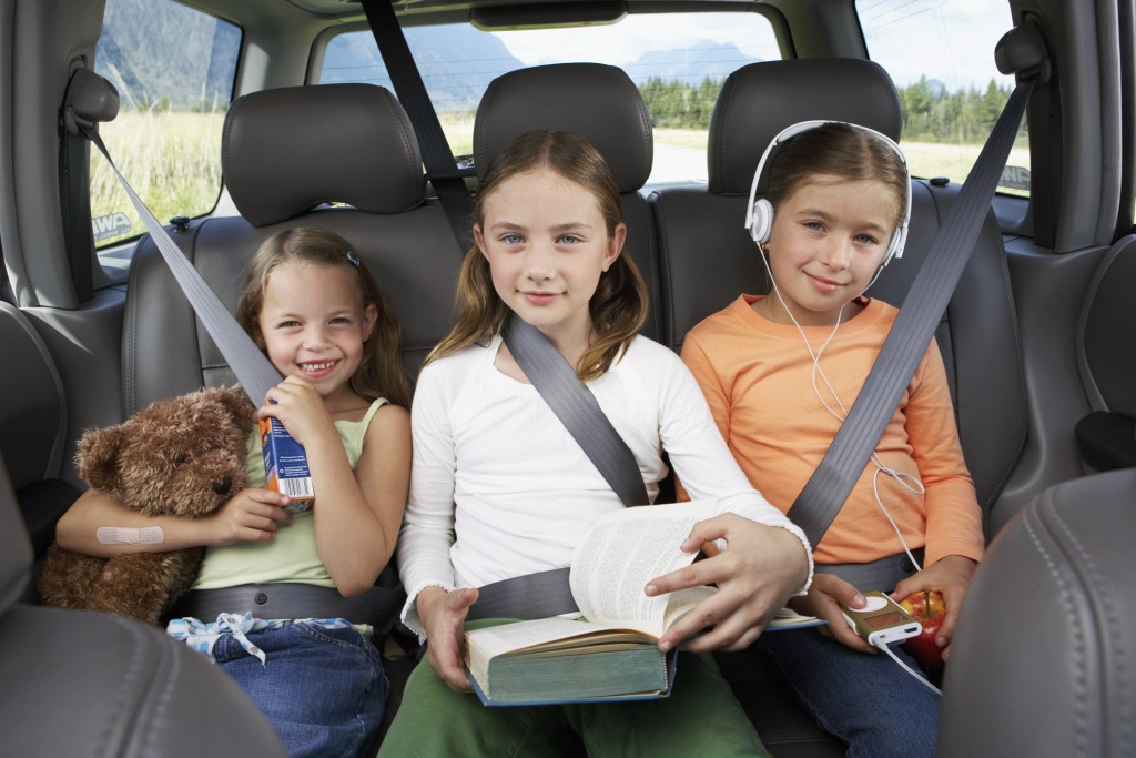 Three Girls (6 8 Years) Sitting On Rear Seat Of Car, Smiling, Portrait