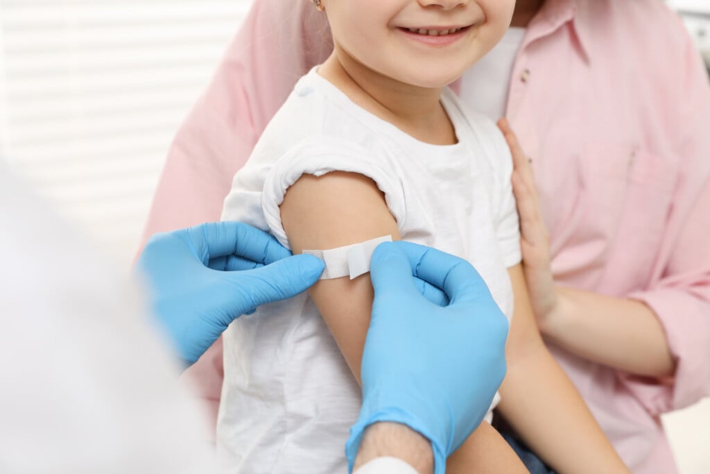 young child getting a bandaid after receiving an immunization, for article on back-to-school immunizations
